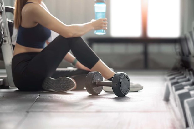Woman in the gym wearing sports bra taking a break