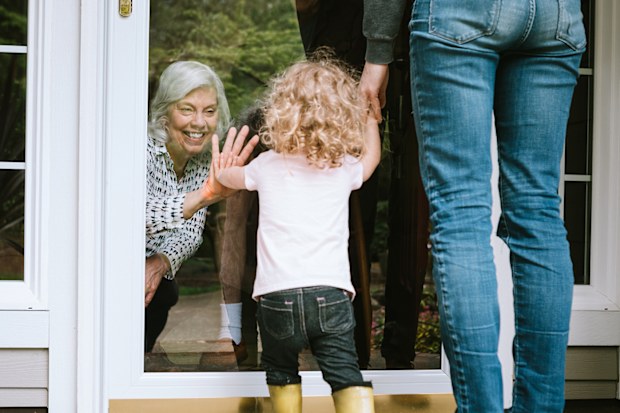 Grandmother greets grandchildren through glass
