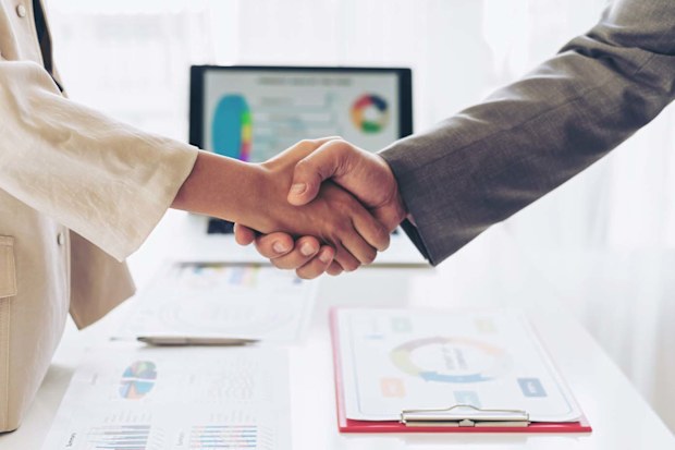 Woman and man handshake in corporate environment.