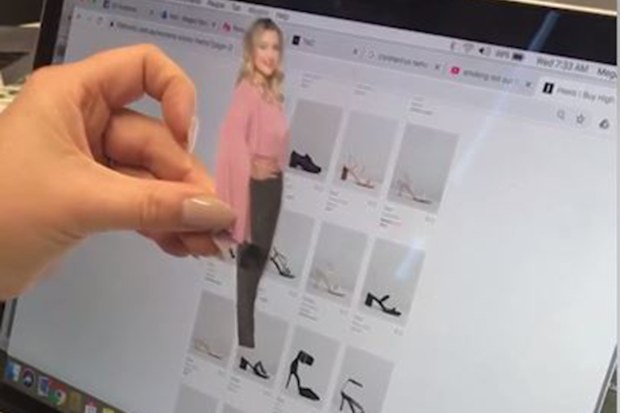 The woman uses a cut out of herself to try shoes.