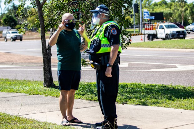 A man talks to a policeman outside a COVID-19 testing station at Marrara Sport Complex in Darwin.