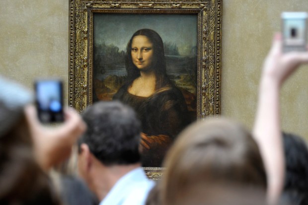 Visitors take pictures of Leonardo da Vinci's Mona Lisa, at the Louvre Museum in Paris
