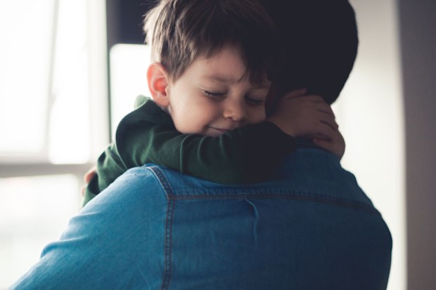 Young boy hugging his father