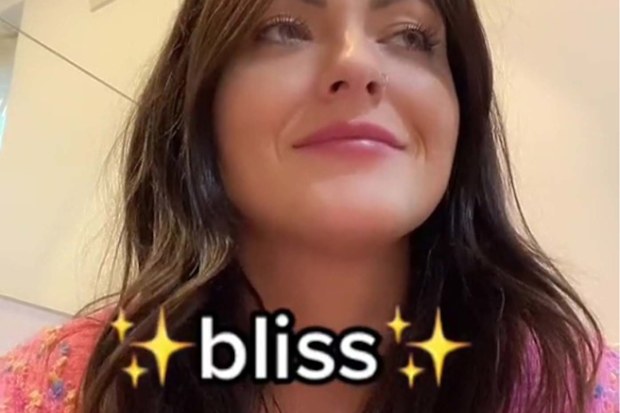 TikTok user facing the camera and looking off screen with the subtitle "bliss"