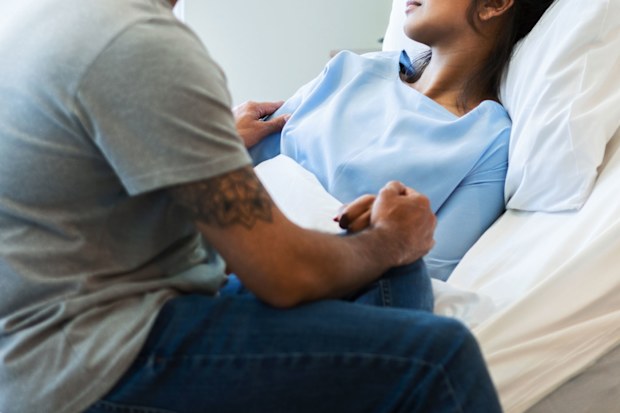 Woman in hospital bed with partner