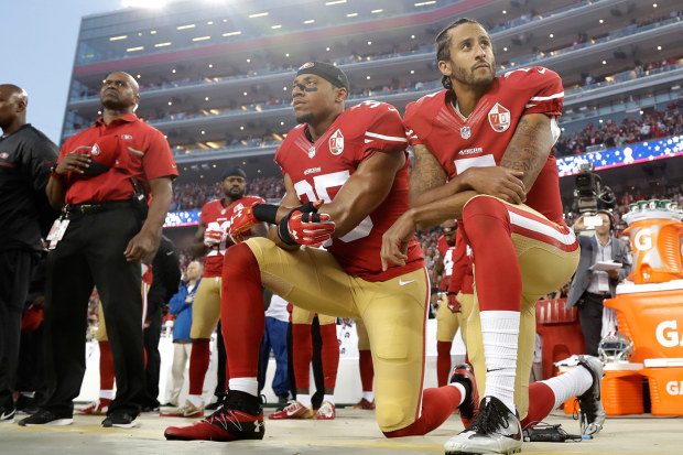 San Francisco 49ers safety Eric Reid (left)) and quarterback Colin Kaepernick kneel during the national anthem before a 2016 NFL football game against the Los Angeles Rams 