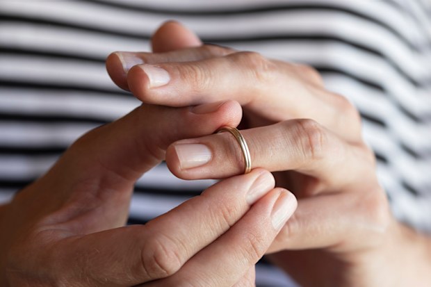 Woman taking off wedding ring.