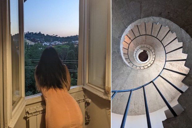 A woman leans stares out of a window overlooking the hills of Florence.