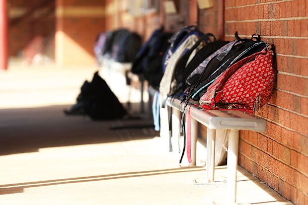 School bags lined up outside classroom.