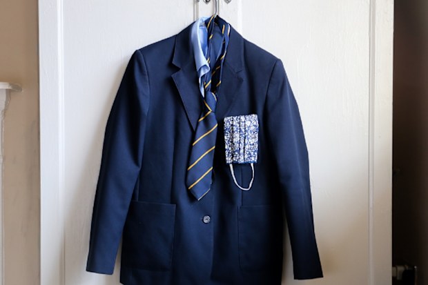 School uniform with face cover hanging up