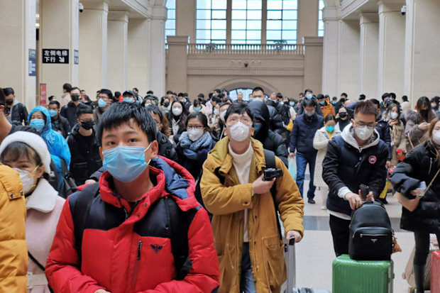 People wear face masks as they wait at Hankou Railway Station on January 22, 2020 in Wuhan, China. 