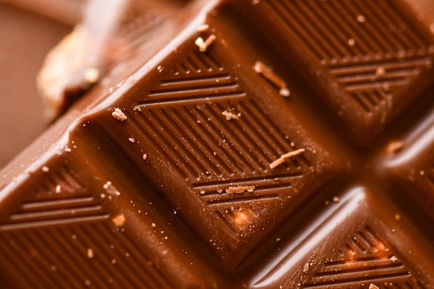Close-up of a chocolate bar capturing reflective highlights, smooth surface, and rich brown tones, perfect for food and dessert imagery.