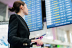 Young businesswoman looking control panel at airport