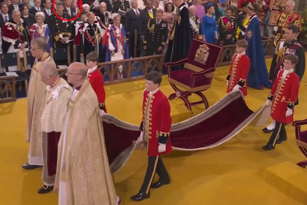 King Charles stands in Westminster Abbey during his coronation. Prince Harry can be seen in the background.