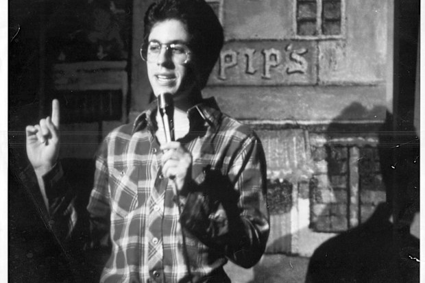 Jerry Seinfeld performing standup at a comedy club