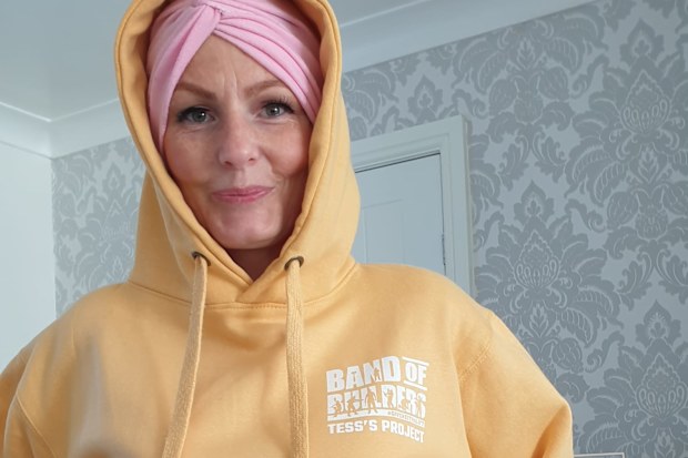 Tess wearing a Band of Builders hoodie. The group of volunteer trades people landscaped the couple's backyard to help Tess recover after her treatment.
