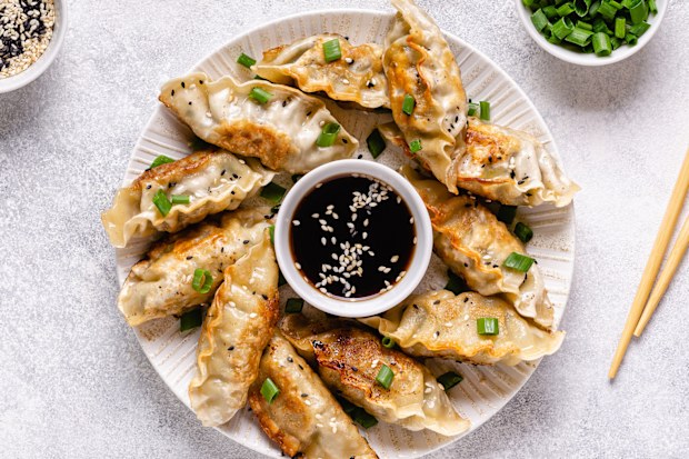 Fried dumplings gyoza with soy sauce, and chopsticks, top view.