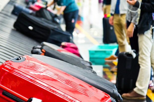 Luggages moving on airport conveyor belt. suitcase with ribbon