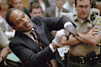 OJ Simpson grimaces as he tries on one of the leather gloves prosecutors say he wore the night his ex-wife Nicole Brown Simpson and Ron Goldman were murdered.