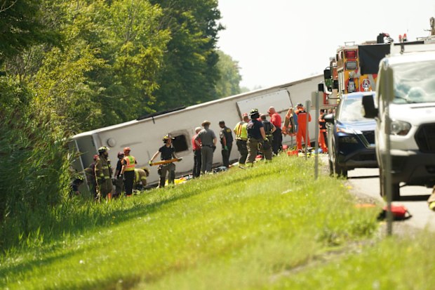 First responders work to rescue victims at the scene of a tour bus that crashed and rolled over on the New York State Thruway.
