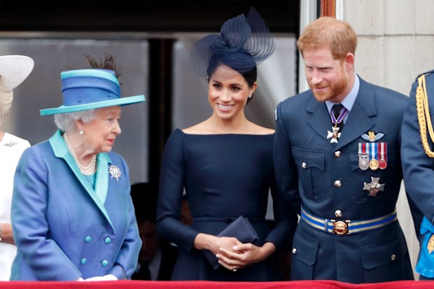 LONDON, UNITED KINGDOM - JULY 10: (EMBARGOED FOR PUBLICATION IN UK NEWSPAPERS UNTIL 24 HOURS AFTER CREATE DATE AND TIME) Queen Elizabeth II, Meghan, Duchess of Sussex and Prince Harry, Duke of Sussex watch a flypast to mark the centenary of the Royal Air Force from the balcony of Buckingham Palace on July 10, 2018 in London, England.
