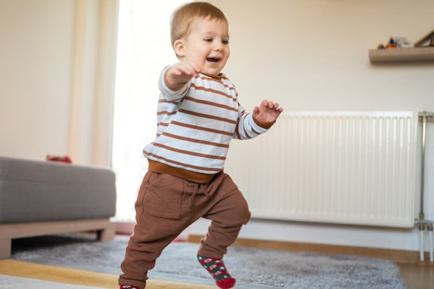 A little boy toddler walking around the house