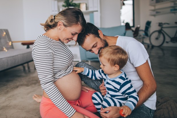Photo of a little boy being curious about his mother's growing belly