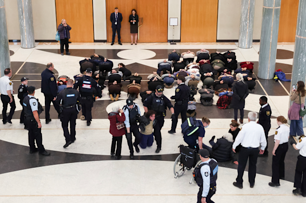 Parliament House security and AFP remove pro-Palestine protestors from the marble foyer of Parliament House in Canberra.