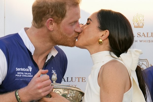 Prince Harry and Meghan Markle, Duchess of Sussex, kiss as she presents his polo team with the trophy for winning the Royal Salute Polo Challenge to Benefit Sentebale, Friday, April 12, 2024, in Wellington, Florida