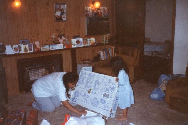 Sapphire Mitchell unwraps a present on Christmas Day with her mum.