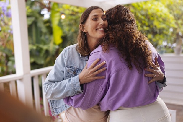 People exchange a welcoming hug