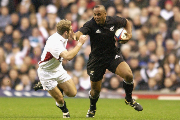 Jonah Lomu of New Zealand goes past James Simpson-Daniel of England.