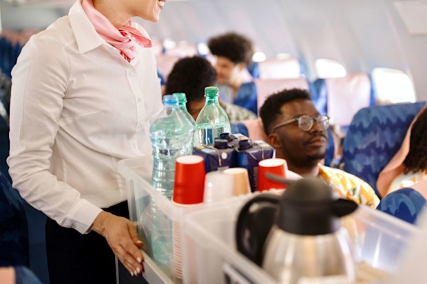 Cabin crew pushing service cart and serve to customer on the airplane during flight