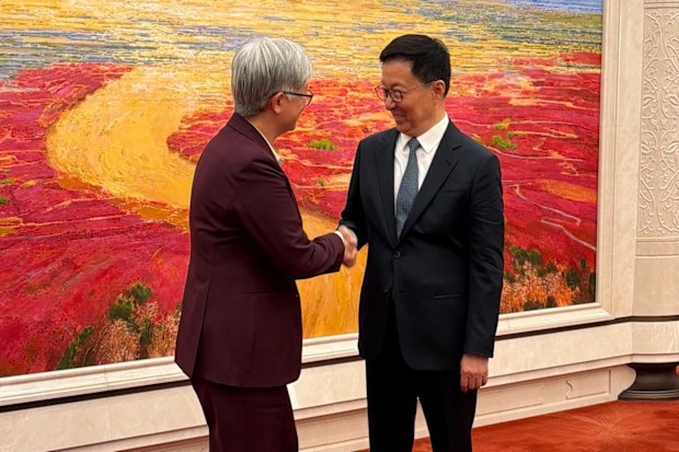 Foreign Minister Penny Wong shaking hands with Vice Premier Han Zheng in Beijing.