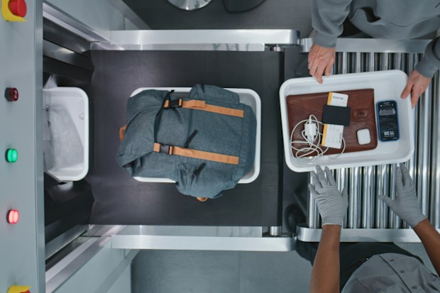 Top View on Diverse People, Passengers Putting Personal Items in Plastic Trays for Screening Procedures in X-ray Scanning Conveyor Belt. TSA Airport Security Checkpoint before Boarding Plane Flight.