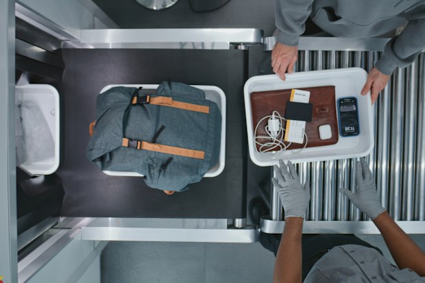 Top View on Diverse People, Passengers Putting Personal Items in Plastic Trays for Screening Procedures in X-ray Scanning Conveyor Belt. TSA Airport Security Checkpoint before Boarding Plane Flight.
