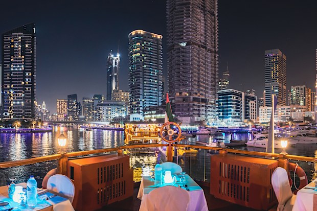 Dubai Marina Port, UAE, United Arab Emirates - Night Walk On Tourist Boat, Sightseeing Boat Sailing On Dubai Marina. Night View Of Dubai Marina Skyline Is District in Dubai, United Arab Emirates. Panorama, Panoramic View.