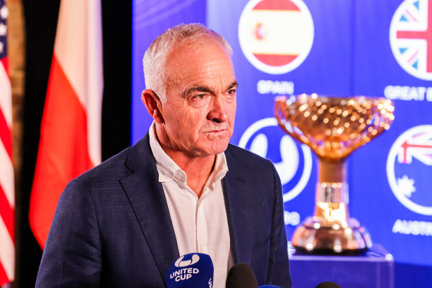 Former professional tennis player and television commentator Wally Masur speaks to media with the United Cup trophy behind him.