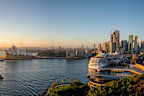 Sydney, Australia - August 05, 2019: The spectacular cityscape of Sydney at dawn. Across the waters of Sydney Harbour we see the iconic form of the city's Opera House and the Harbour beyond. The cruise ship Carnival Spirit is moored tied up at the Overseas Terminal.