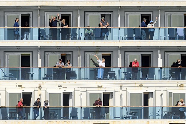 Passenger aboard the Grand Princess celebrate as they arrive in Oakland, California. The cruise ship, which had maintained a holding pattern off the coast for days, is carrying multiple people who tested positive for COVID-19.
