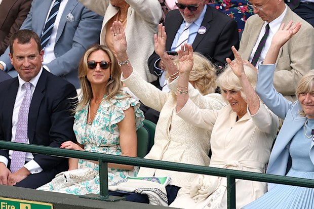 Britain's Queen Camilla participates in a Mexican wave with Deborah Jevans, Chairwoman of the AELTC during day ten of The Championships Wimbledon 2024 at All England Lawn Tennis and Croquet Club on July 10, 2024 in London, England. 