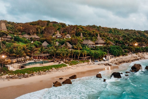 Indonesia Sumba Island Coast. Warm early sunset twilight over Sumba Nihisumba Beach. Indian Ocean Waves splashing towards the natural exotic beach and rock boulders close to Dusk. Aerial Drone View over the Ocean and Beach Rocks and Boulders. Sumba Island, Nusa Tenggara Timur, Indonesia, Southeast Asia