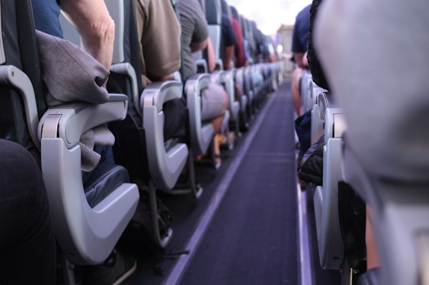 People sitting in the aisle of the plane