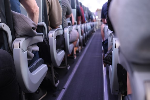 People sitting in the aisle of the plane