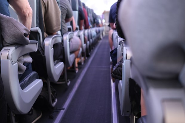 People sitting in the aisle of the plane