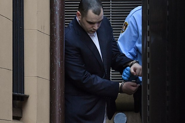 Matthew Flame in handcuffs is led out of the King Street Court building into a prison van on October 23.