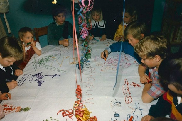At Kris' ninth birthday in 1987, the kids doodled and drew on a bedsheet. Amelie is seen in the top middle with the white collar, and Kris is second from the right in the plaid shirt.