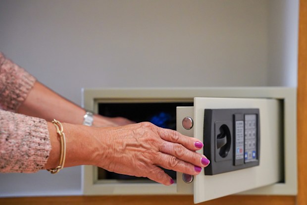 Unrecognizable woman opening the safe in a hotel