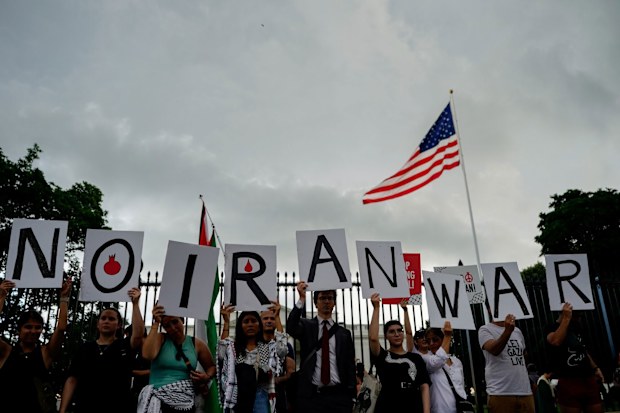 Demonstrators hold signs during a protest against war with Iran outside the White House in Washington, DC, US, on Wednesday, June 18, 2025. President Donald Trump concluded a meeting Wednesday with top advisers as he weighed whether to plunge the US into the ongoing war between Israel and Iran, but the White House offered few clues about whether he had decided to join the offensive aimed at destroying Tehrans nuclear program. Photographer: Kent Nishimura/Bloomberg
