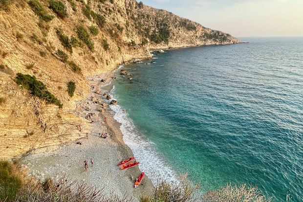 Aerial view of paradisiac Filikuri beach with red canoes and turquoise blue water in Himare, Albania.